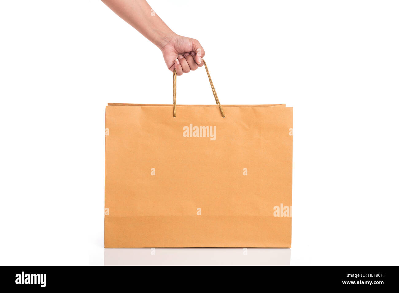 Close up hand holding brown paper bag isolated on white background ...