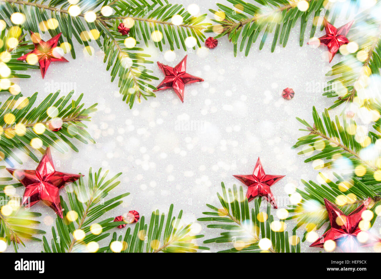 Fir tree branches and star shaped Christmas ornaments on sparkling ...