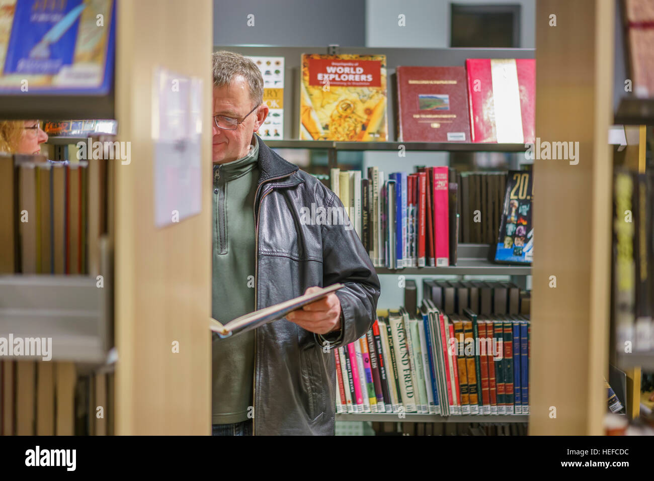 Man reading a book at the Kopavogur library, Kopavogur, Iceland Stock Photo