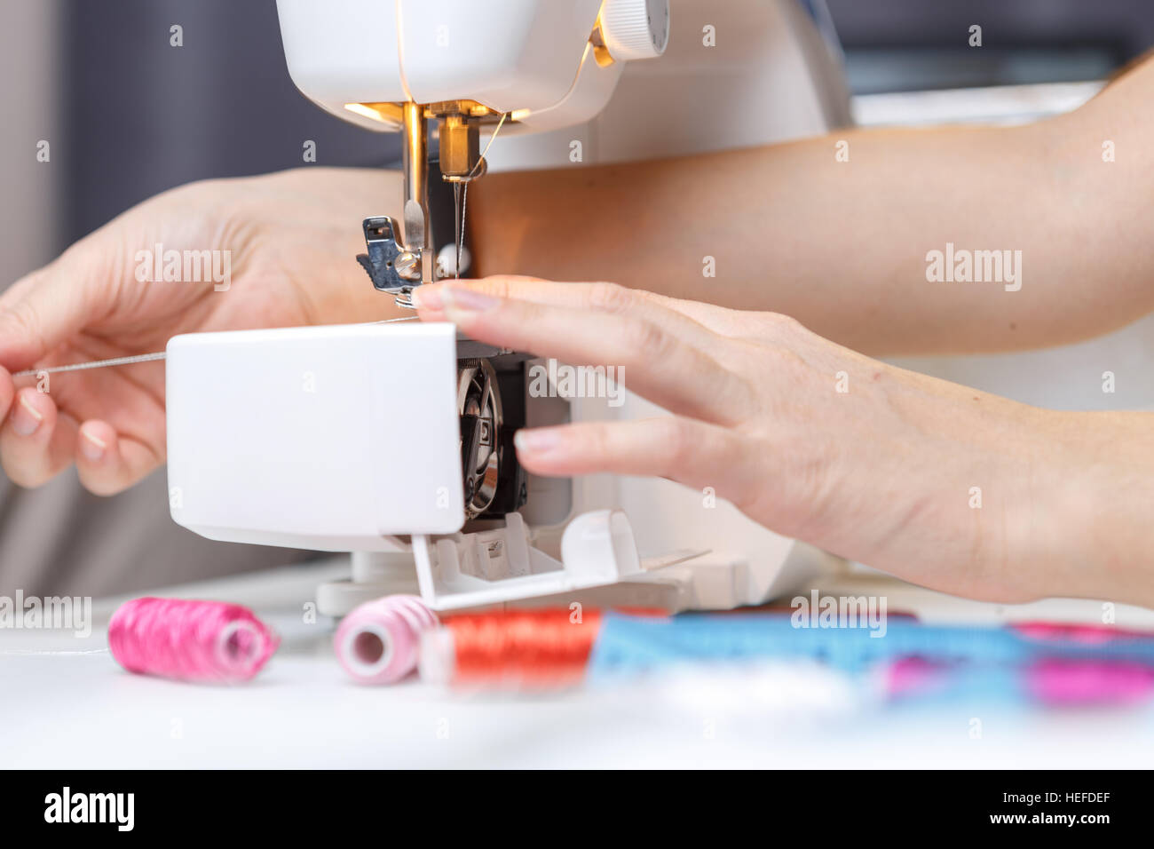 Girl starts tailoring on sewingmachine Stock Photo Alamy