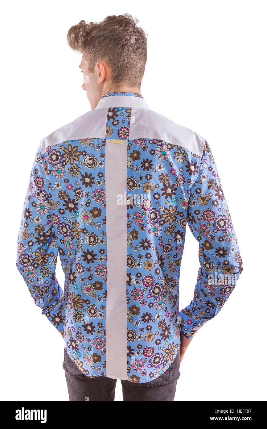 Young blond stylish man dressed in a floral seventies inspired blue, brown and white shirt with black trousers, from rear Stock Photo