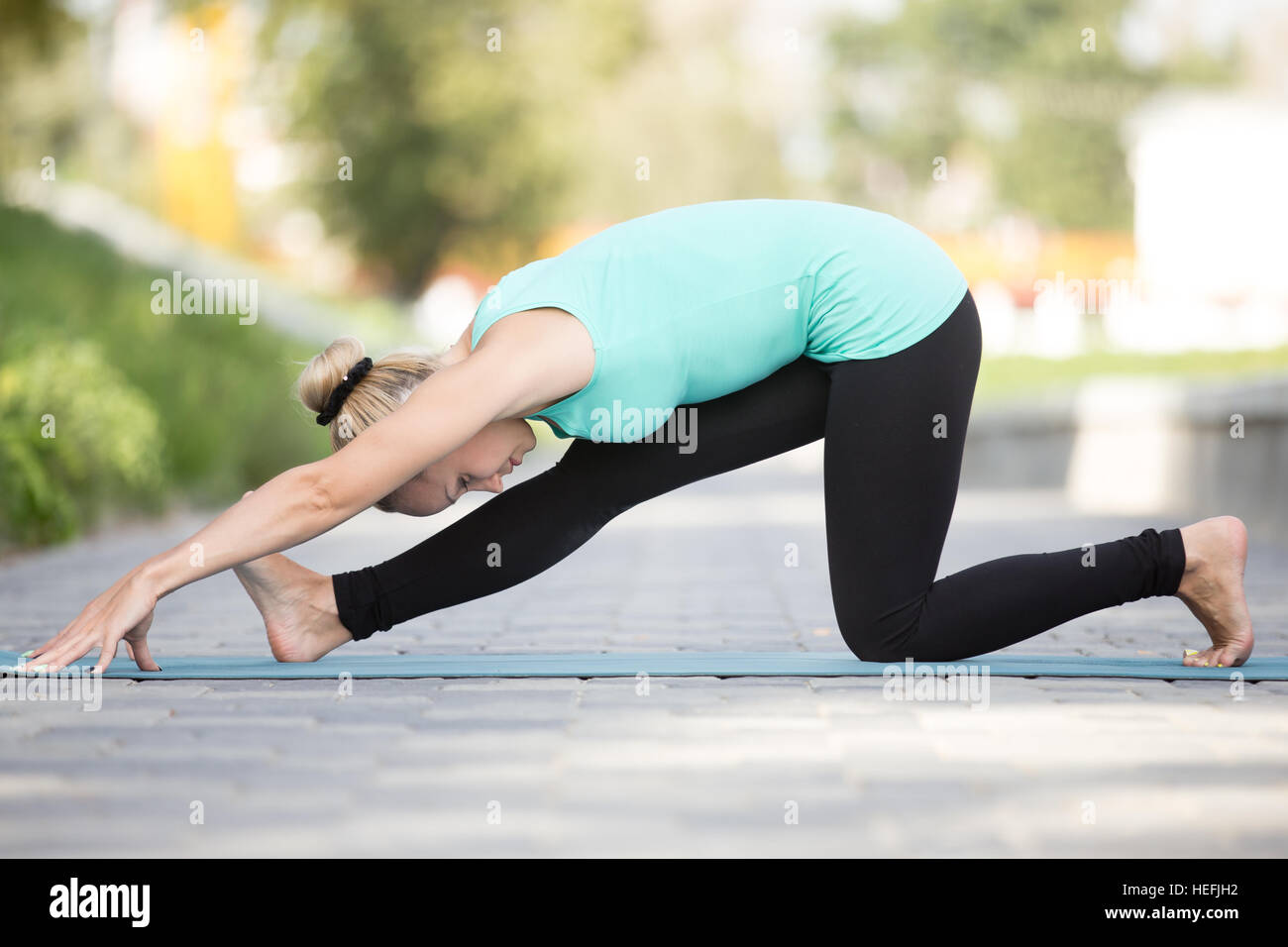 Young woman practicing yoga, doing Half splits exercise, Ardha Hanumanasana  pose, working out, wearing sportswear, black pants and top, indoor full  length, gray wall in yoga studio Stock Photo | Adobe Stock