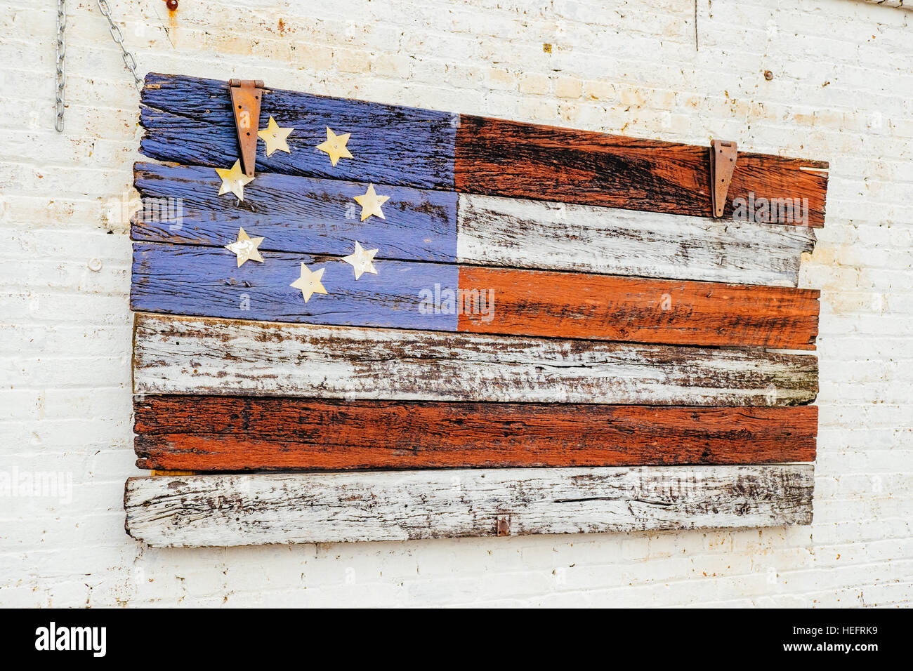 Painted American flag on wood hanging on the exterior of a building in south central Alabama USA. Stock Photo