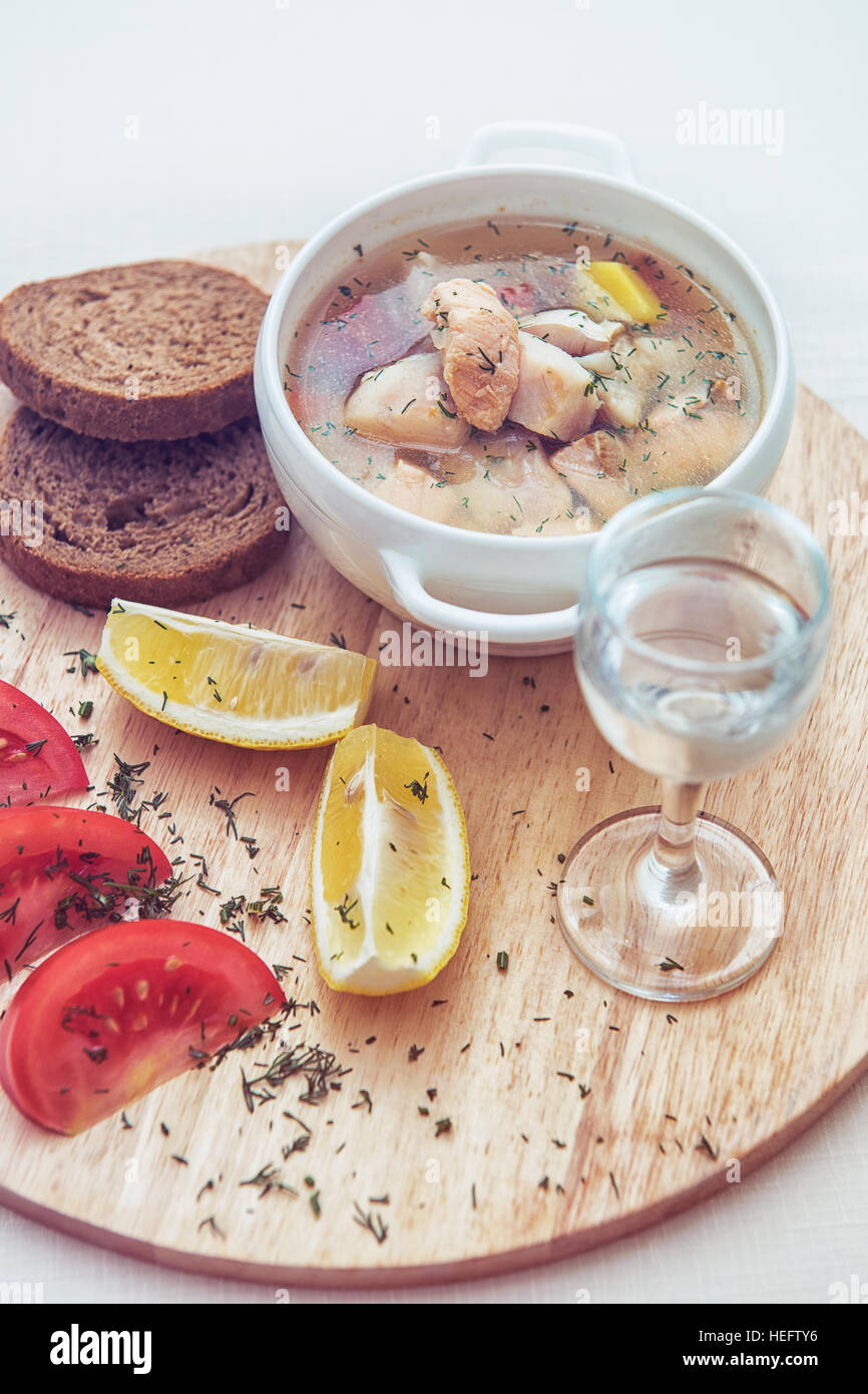 Russian traditional fish soup ukha, served with bread lemon tomato