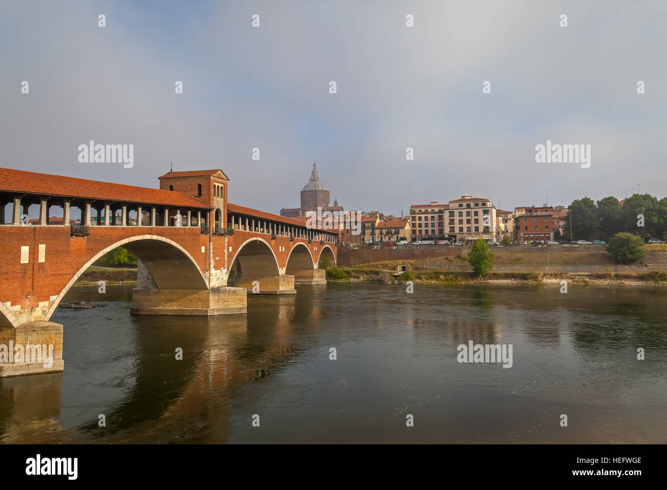 View of the Old Bridge (Ponte Vecchio) and the Dome in Pavia. Italy. Stock Photo