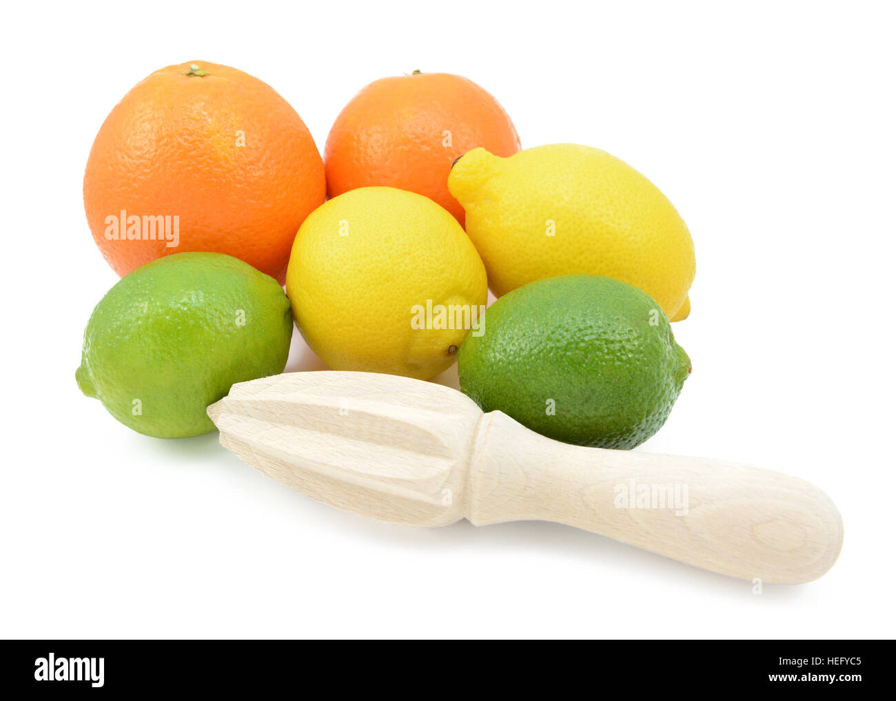 Six citrus fruits - limes, lemons and oranges - with a wooden reamer, isolated on a white background Stock Photo