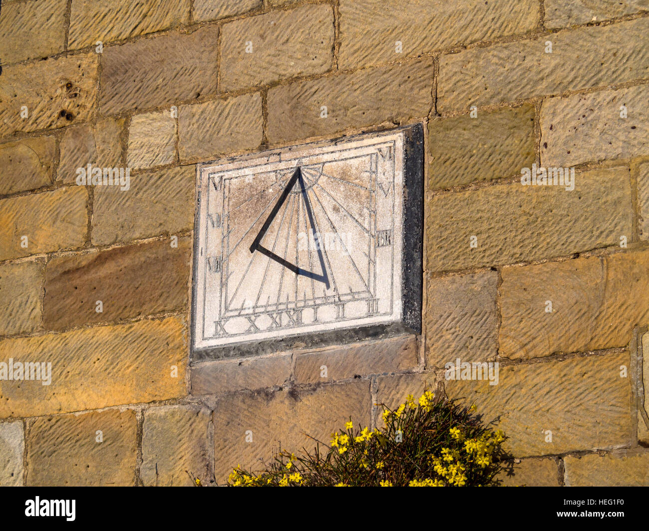 A simple sundial on a south facing sandstone wall in Danby North Yorkshire Stock Photo