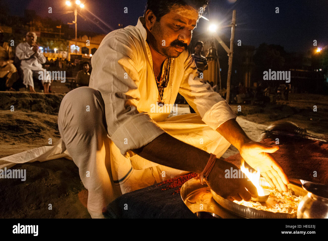 Hindu brahmin priest performs a fire ritual at night in Varanasi, Uttar Pradesh, India, Asia Stock Photo