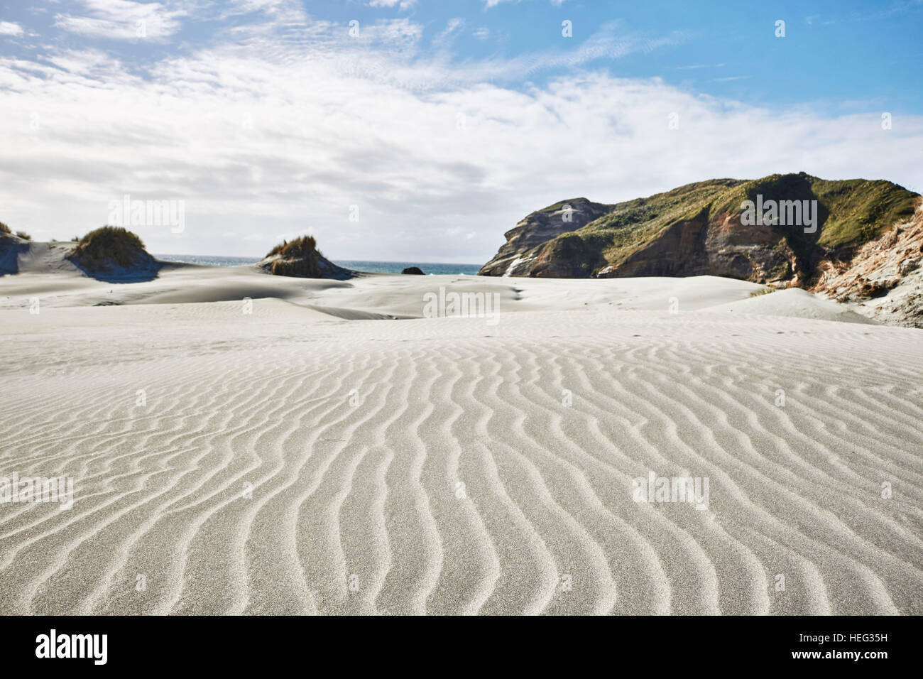 New Zealand, south island, Wharariki Beach, dunes and beach by the sea, tracks in Sand, structure, sunny, cloudy sky Stock Photo
