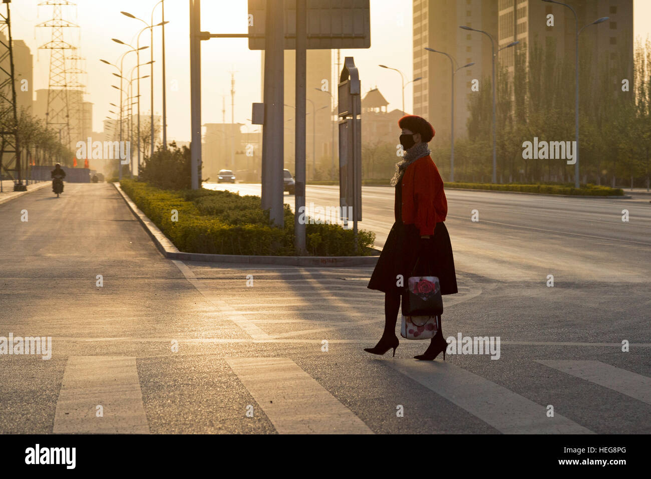 Silhouette of Chinese pedestrian crossing the street at sunset, Yinchuan, Ningxia, China Stock Photo