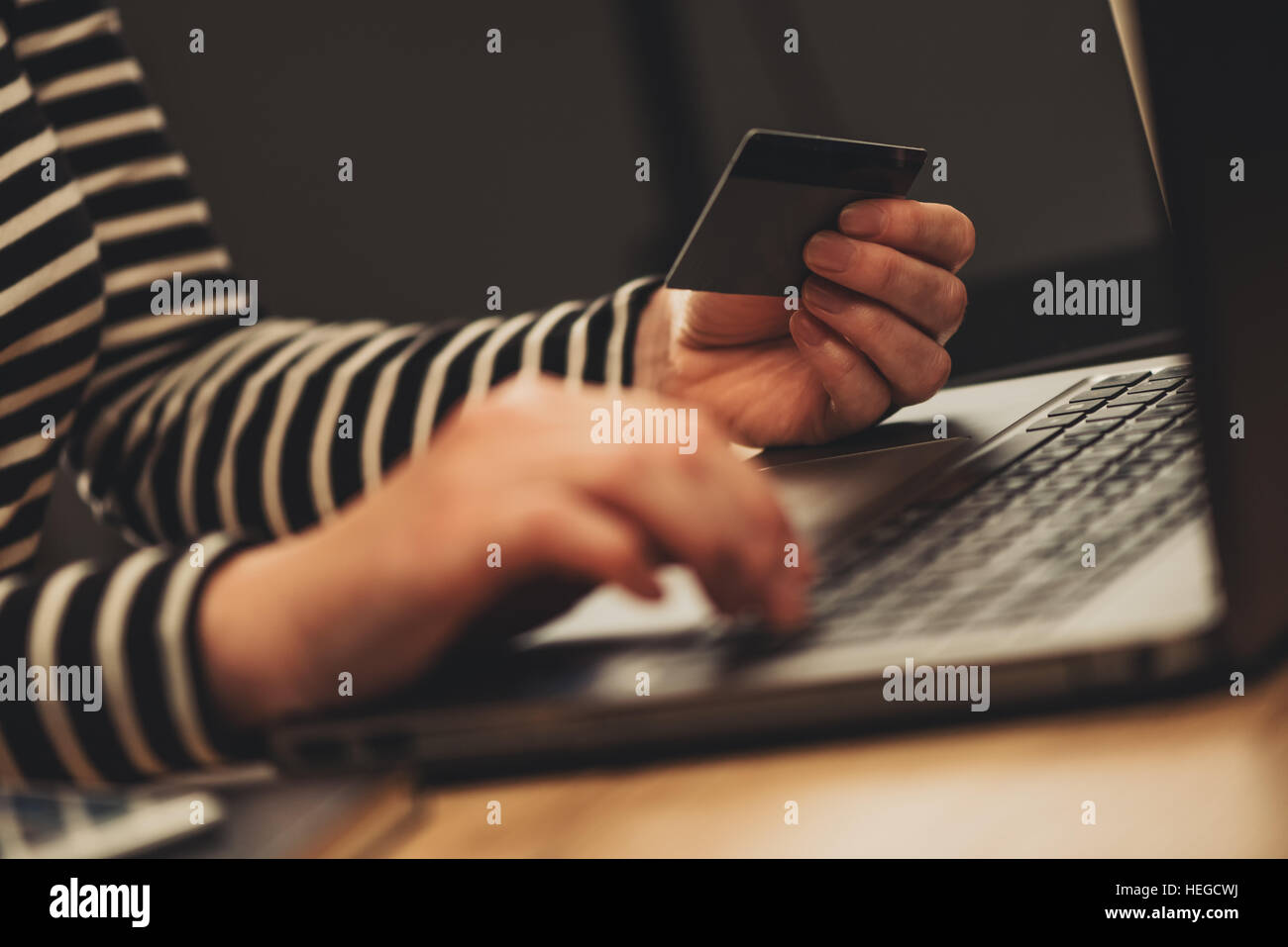 E-commerce concept - woman using laptop and credit card, close up of female hands typing e-wallet credentials for an online purchase transaction Stock Photo