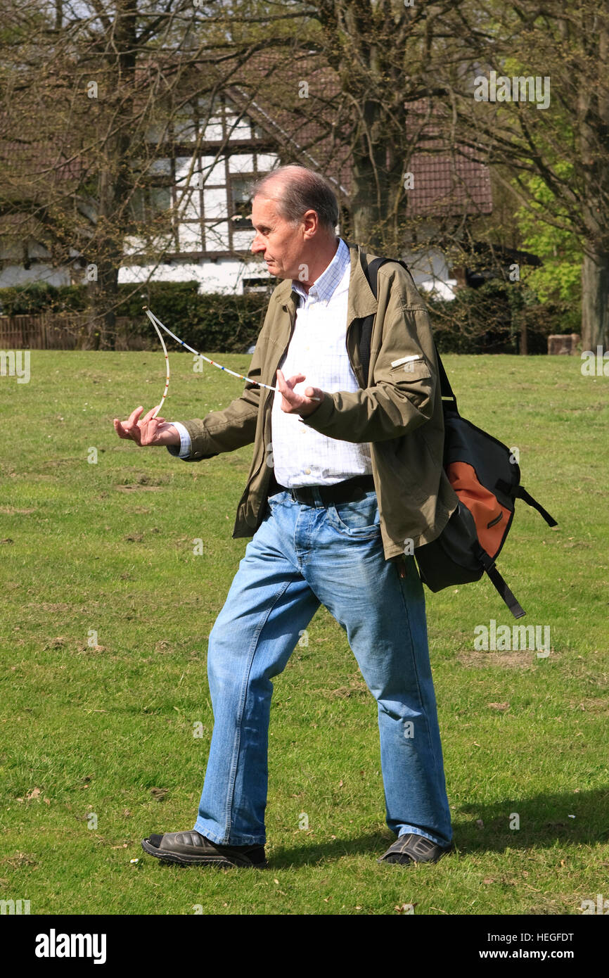 Germany, Dortmund, a geomancer with a dowsing rod searching for water veins and earth rays Stock Photo