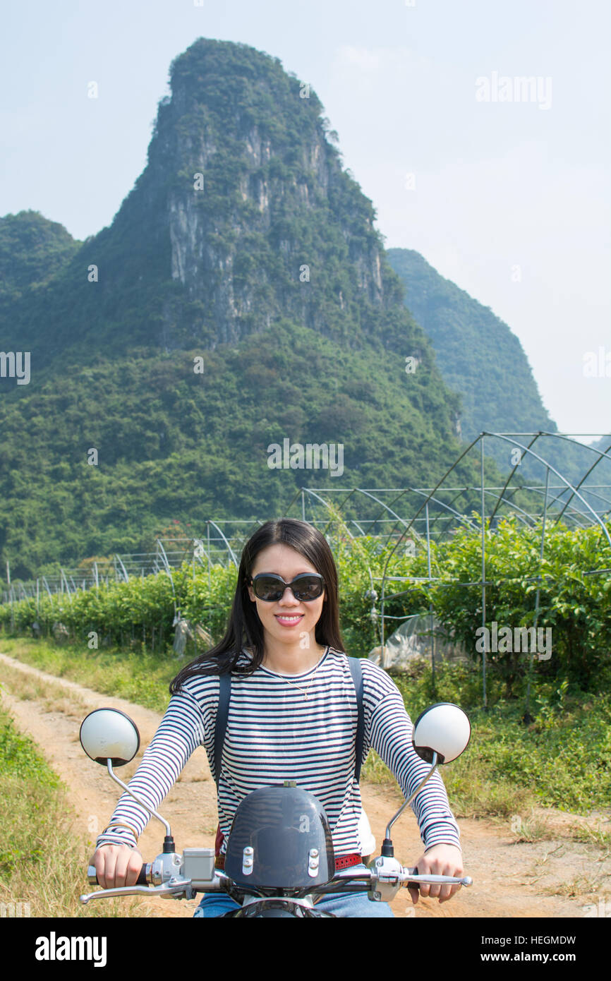 Girl on a motorbike in the scenic nature area Stock Photo