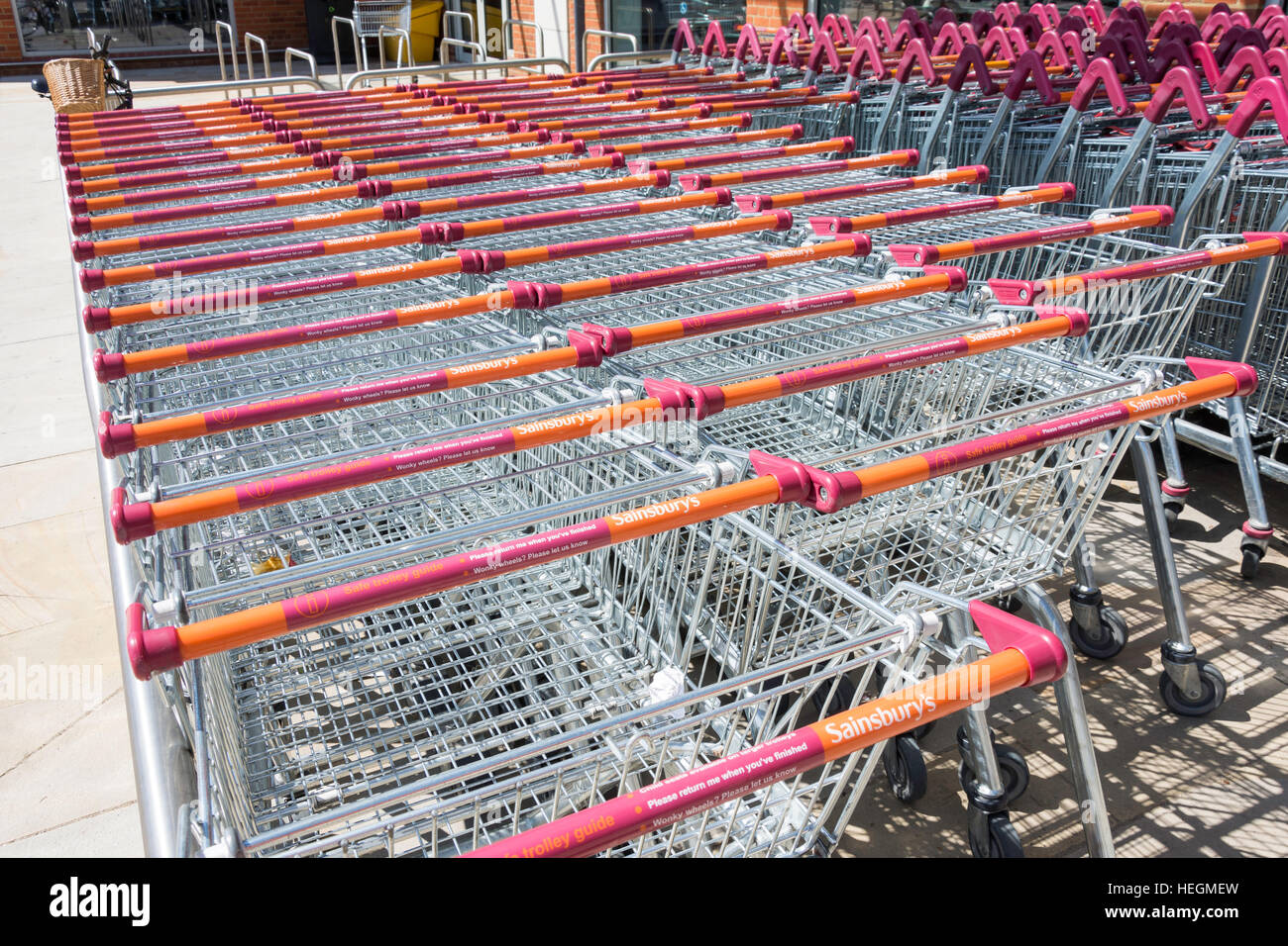Stack of trolleys at entrance to Sainsbury's Supermarket, Hartham Lane, Hertford, Hertfordshire, England, United Kingdom Stock Photo
