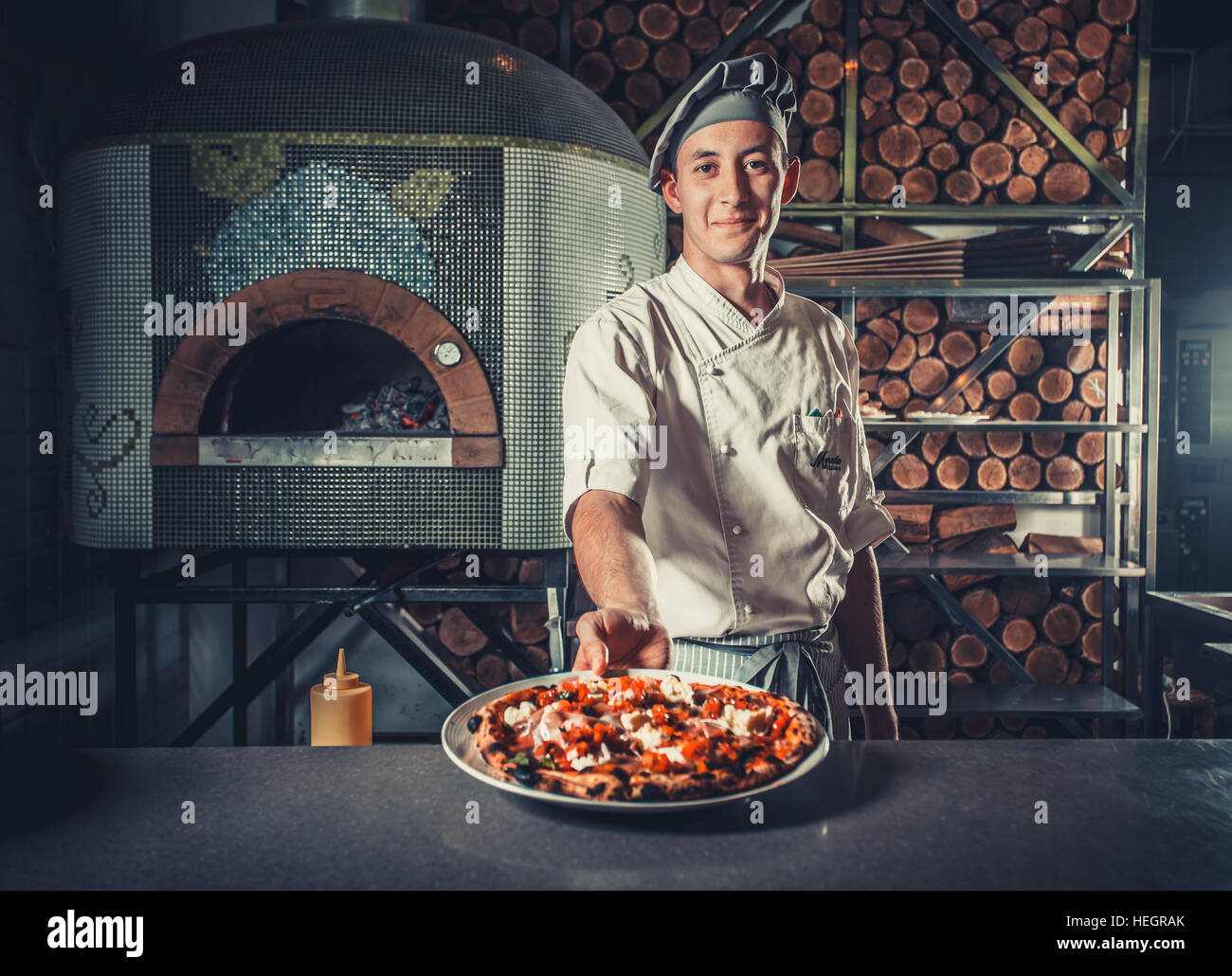 Man cook holding fresh cooked pizza Stock Photo