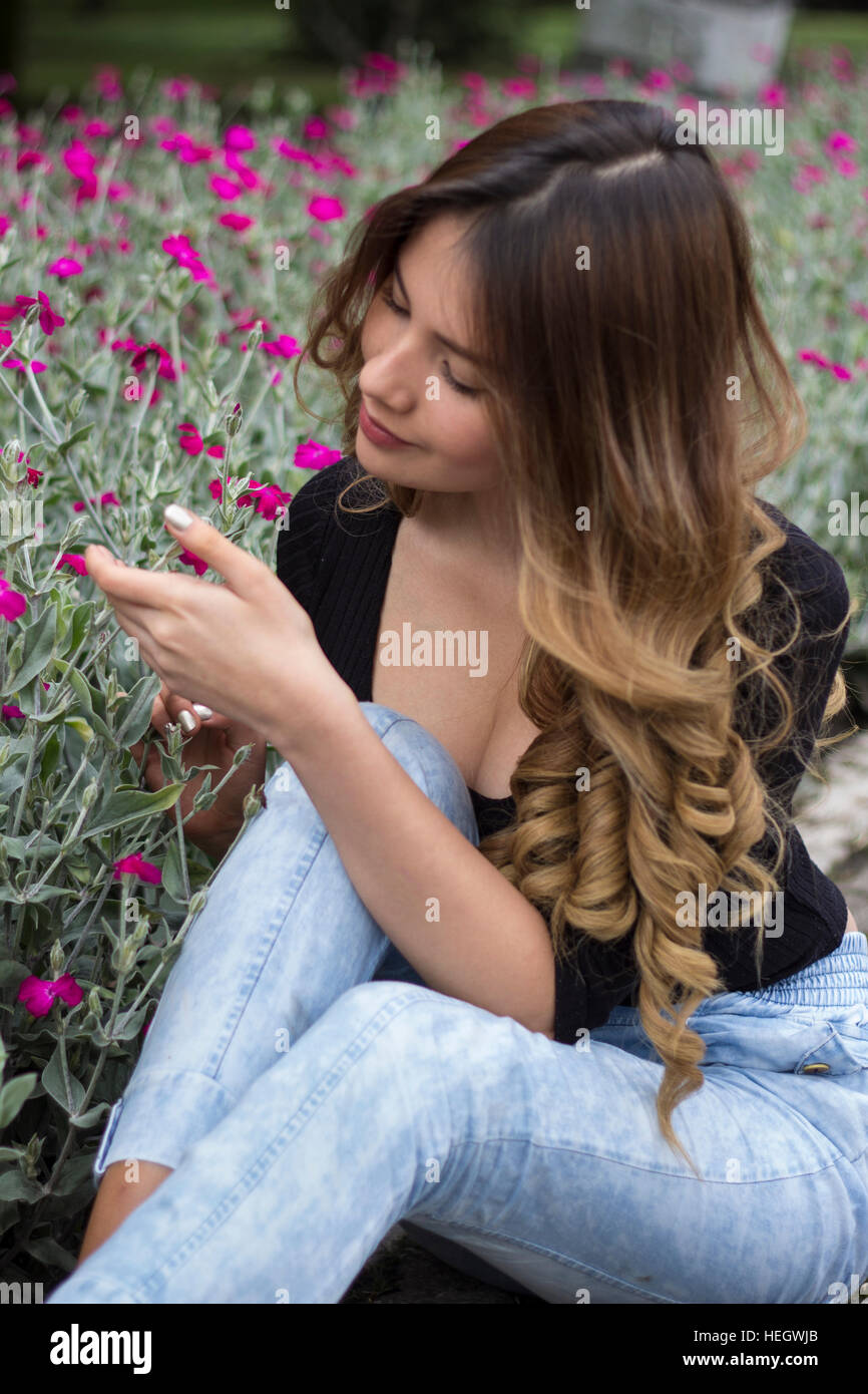 Pretty girl touching flowers Stock Photo