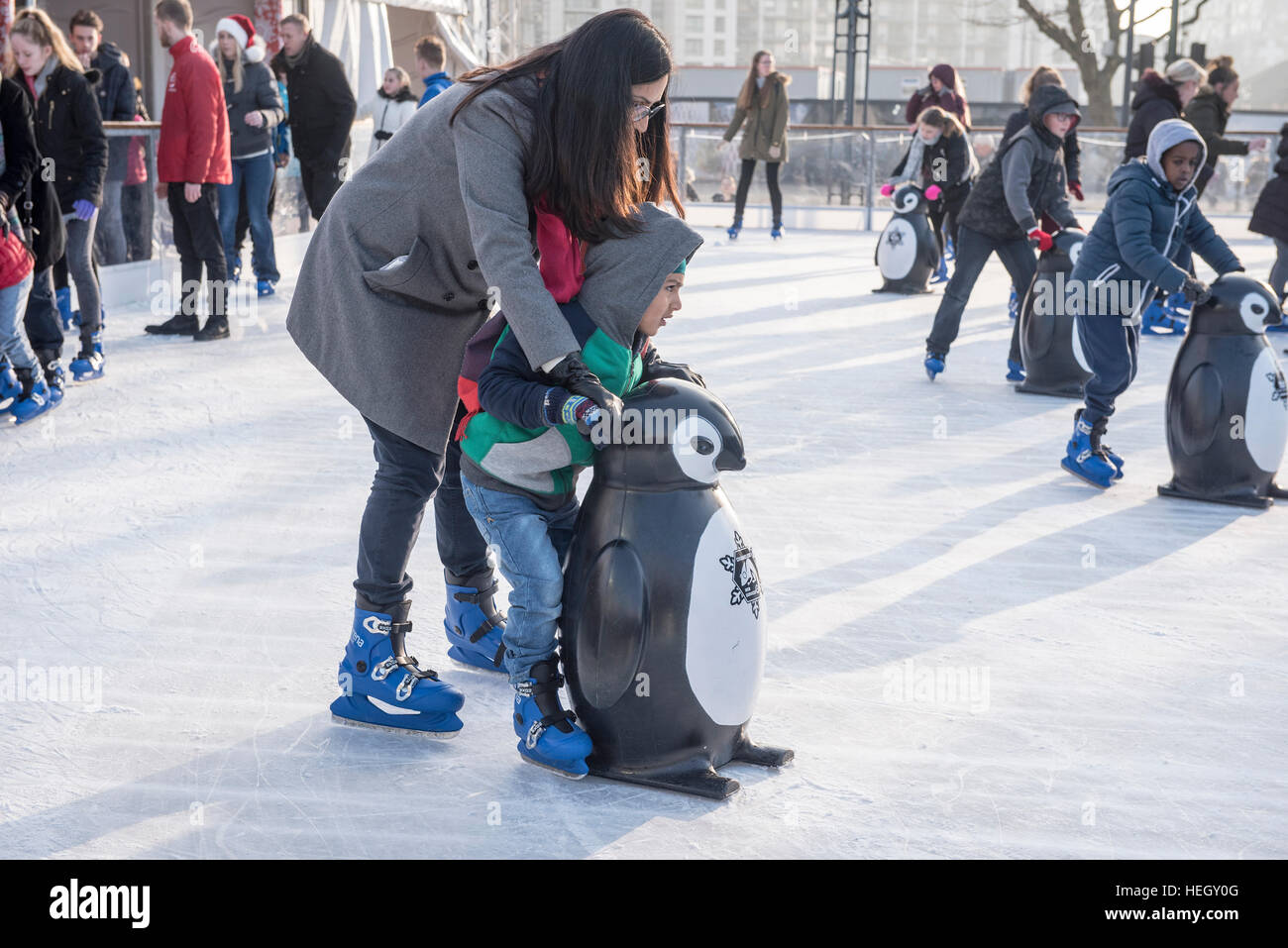 Families and children having fun on outdoor ice skating rink