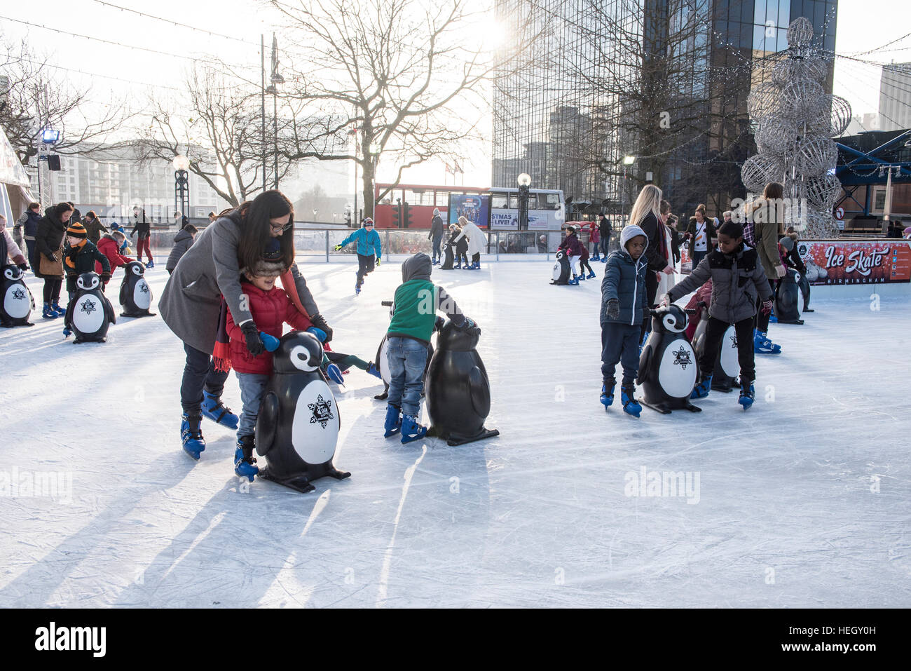 Families and children having fun on outdoor ice skating rink