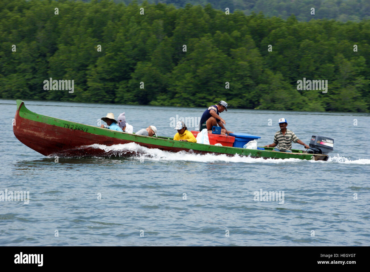 Malay fishermen in a boat. Fishing village on the water. Mengkabong