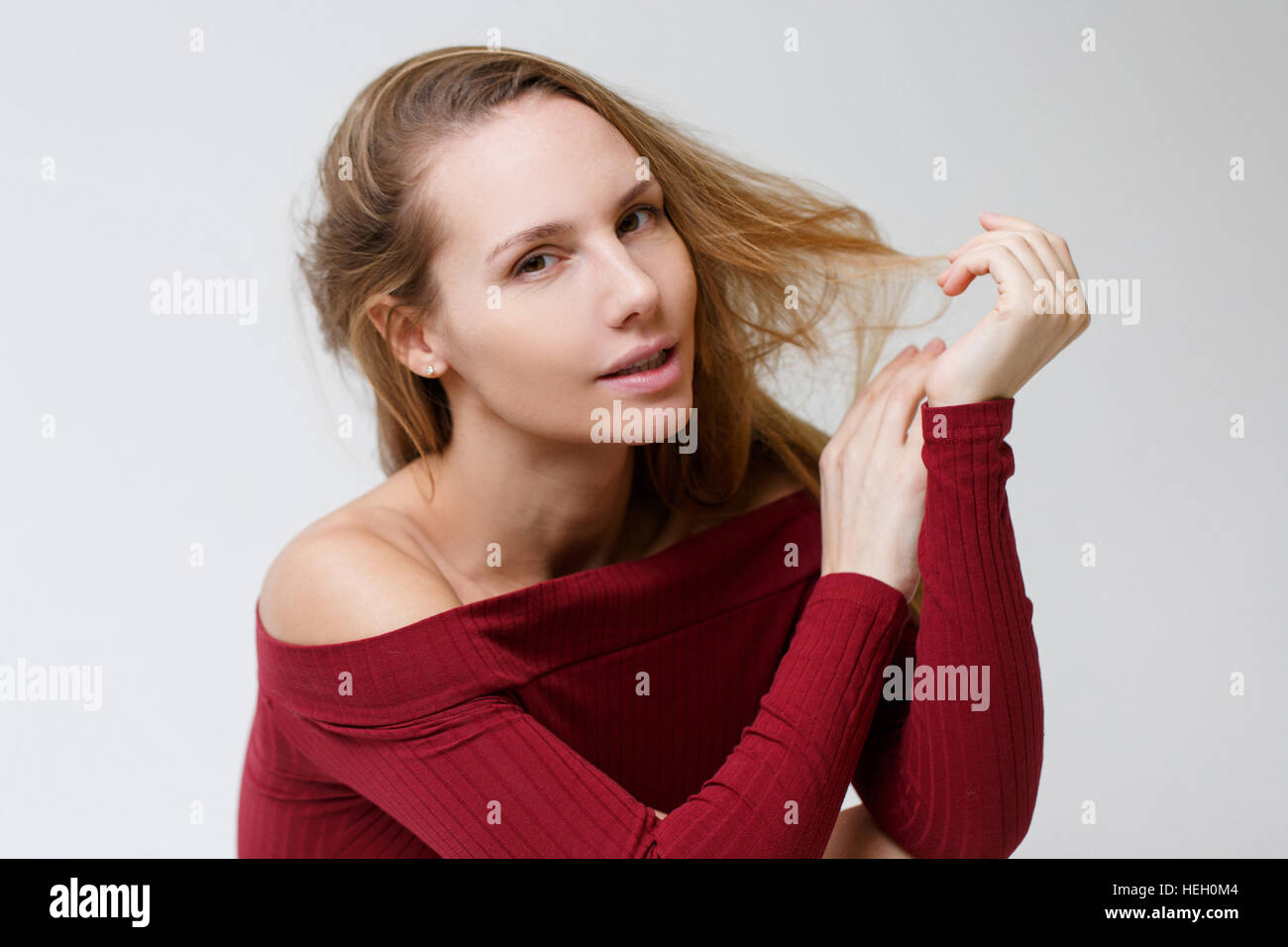 Girl in red dress sitting in studio on gray background empty Stock ...