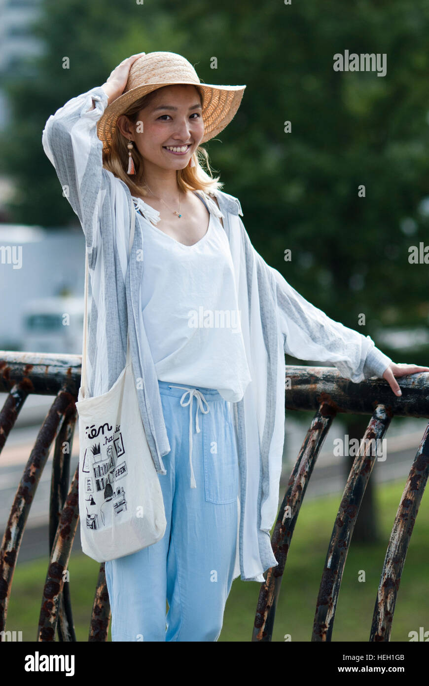 Happy, beautiful Japanese girl wearing a straw hat and smiling at the camera Stock Photo