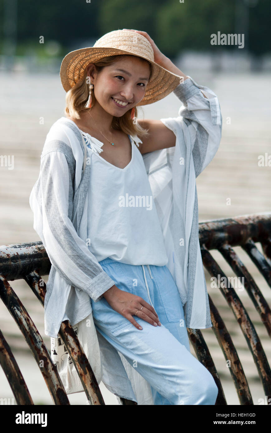 Happy, beautiful Japanese girl wearing a straw hat and smiling at the camera Stock Photo