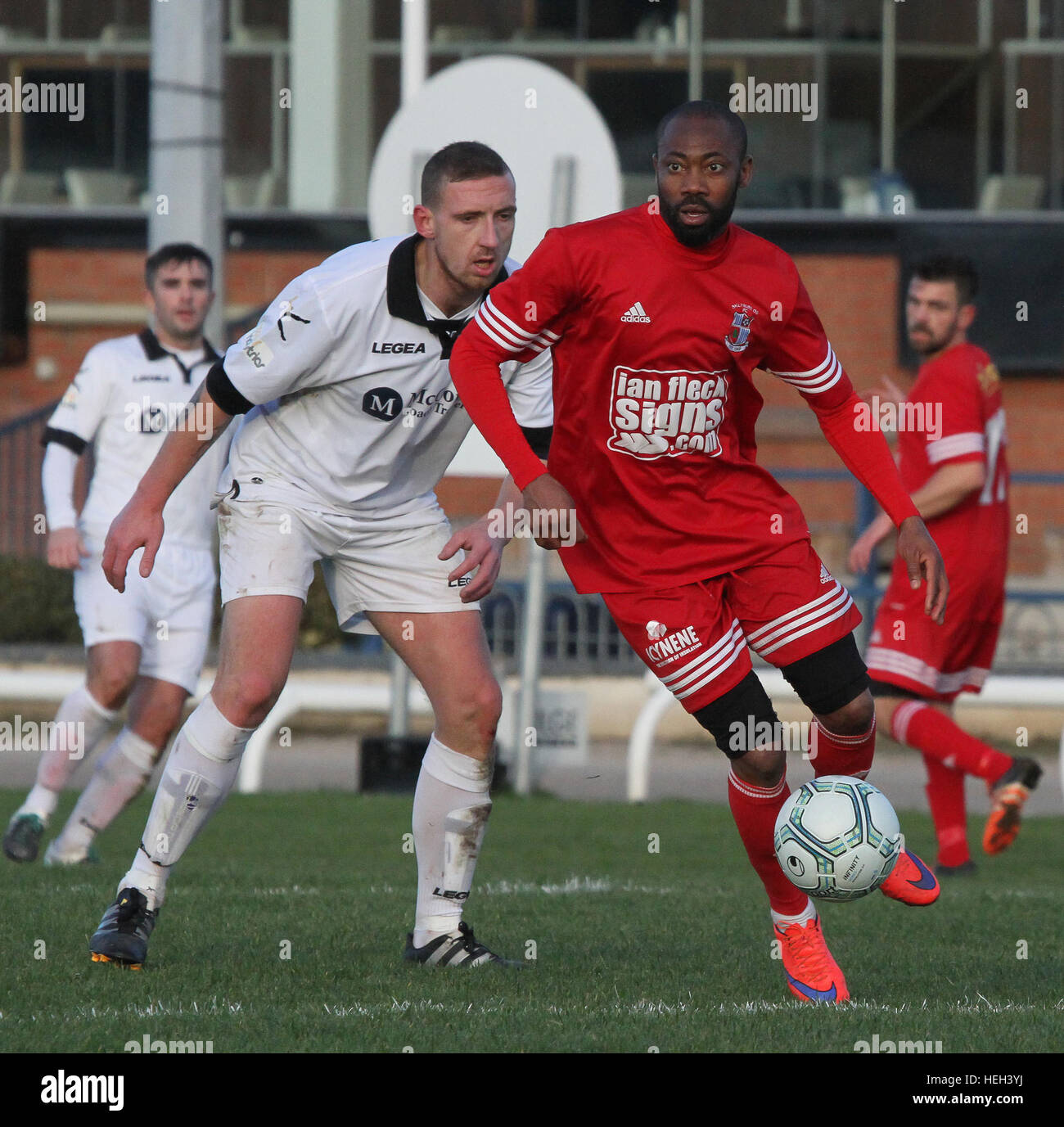 Former Nigerian International Kevin Amuneke (red) playing for Northern Ireland junior side Ballynure Old Boys in the Intermediate Cup against Lisburn Distillery in November 2016. On the 22nd December 2016 local media announced that Amuneke would be joining Irish Premier League side Linfield in the January 2017 transfer window. Stock Photo