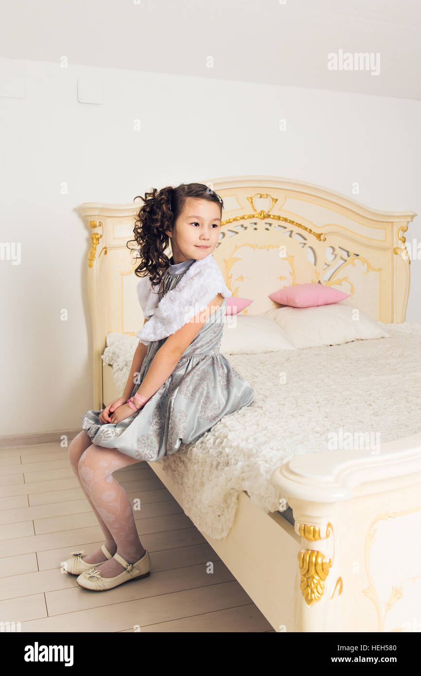 Portrait of adorable asian girl sitting on the bed Stock Photo - Alamy