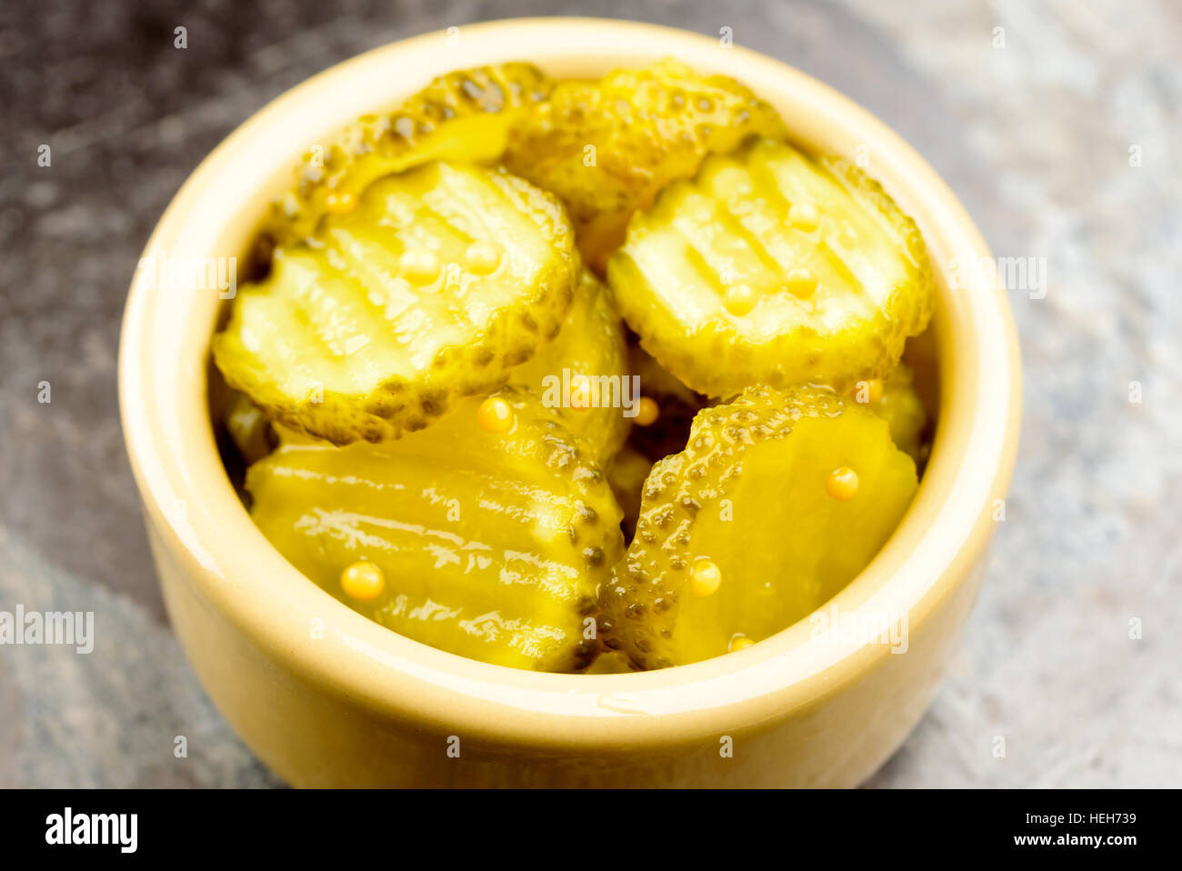 Fresh homemade pickled cucumber with mustard seeds in small ceramic bowl Stock Photo