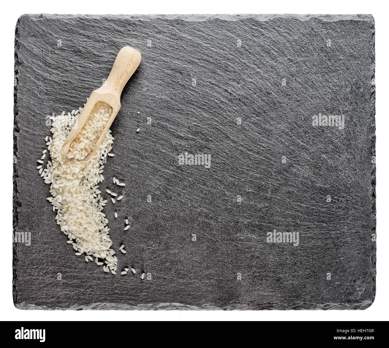 Slate Rice White rice with wooden spoon on slate board isolated on white ...