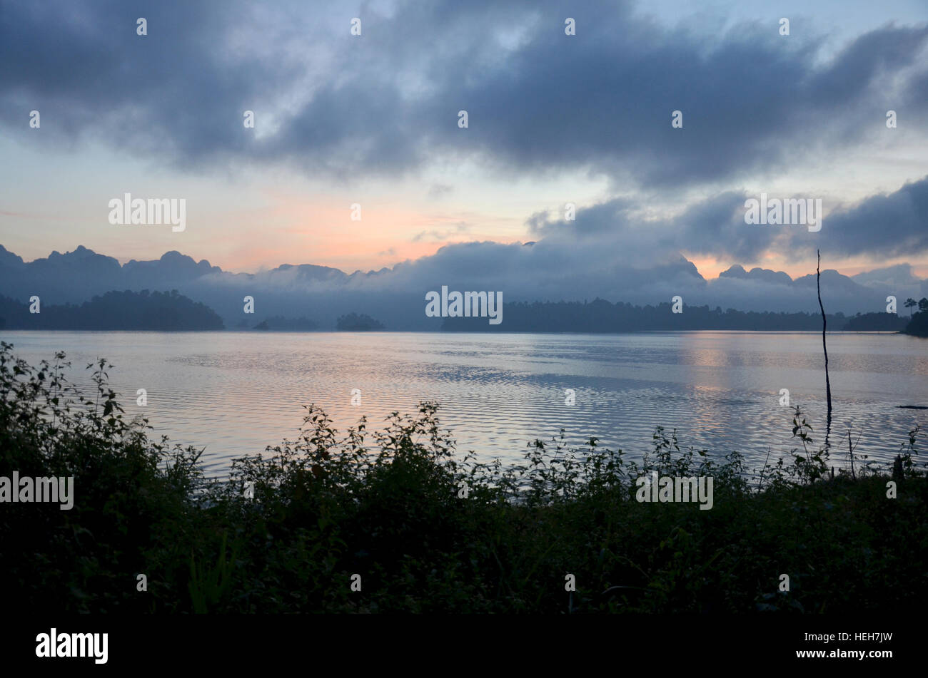 Sunrise with Limestone rocks mountain in morning time at Khao Sok Nation Park in Cheow Lan Lake at Ratchaprapa or Rajjaprabha Dam Reservoir in Surat T Stock Photo