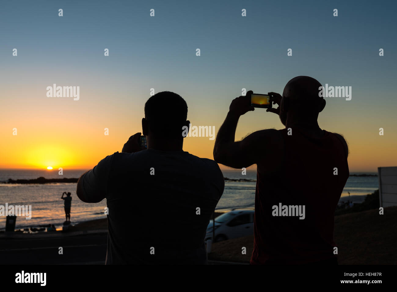 People taking photos of a sundown with their smartphones Stock Photo