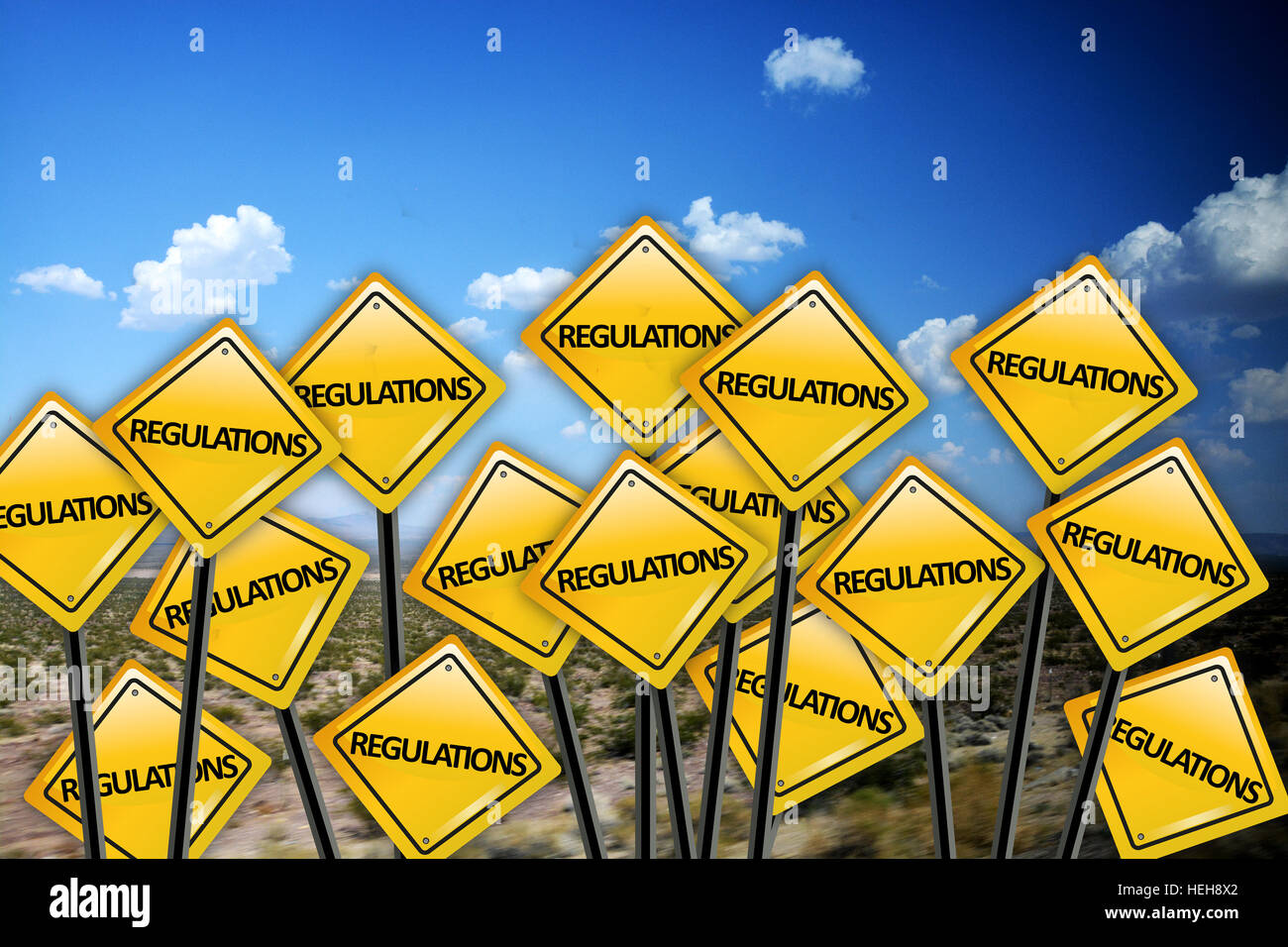 Regulation concept on yellow road sign with blue sky and white clouds Stock Photo