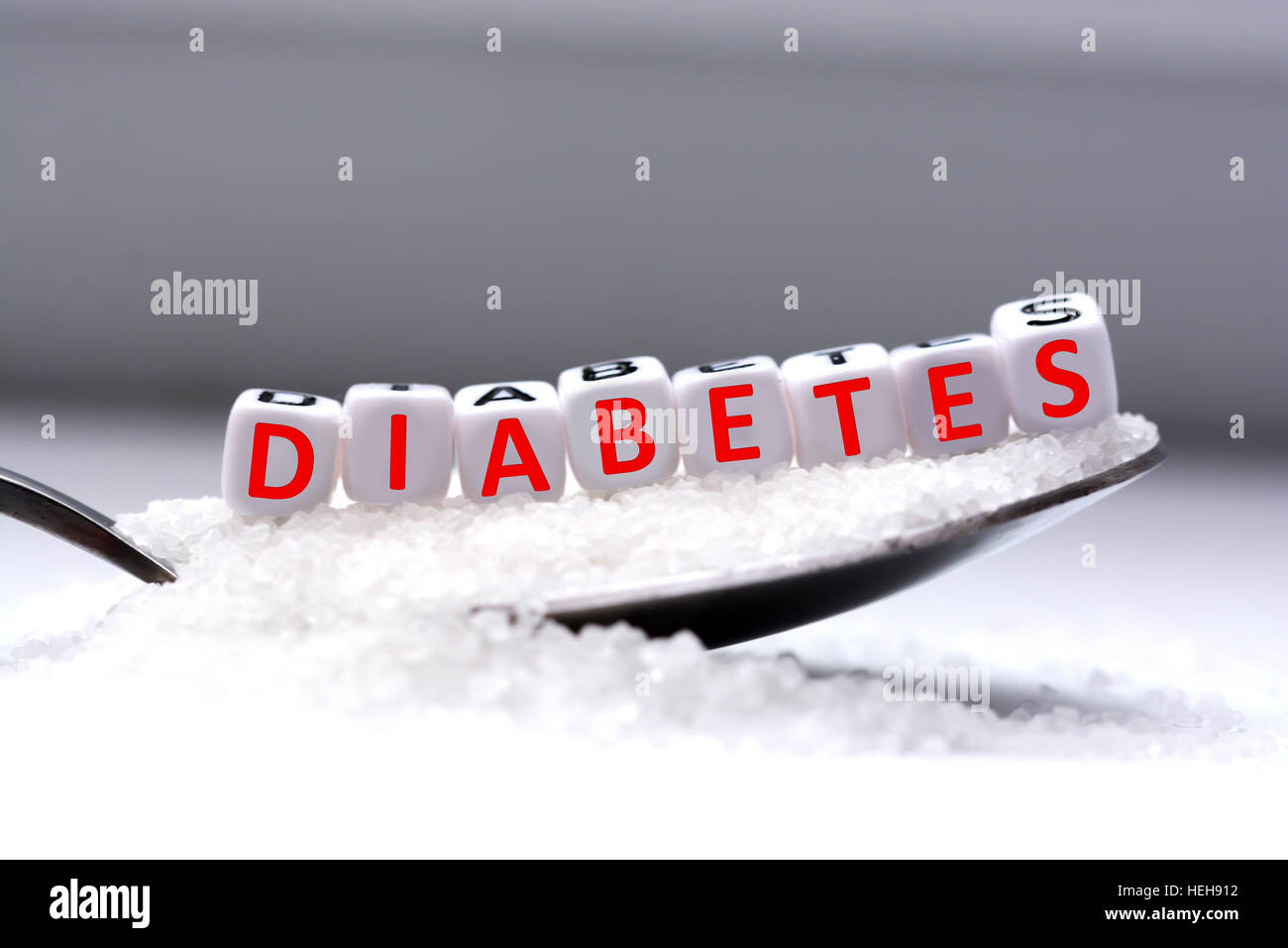Plastic letter beads spelling “diabetes” in a spoon full of sugar Stock Photo