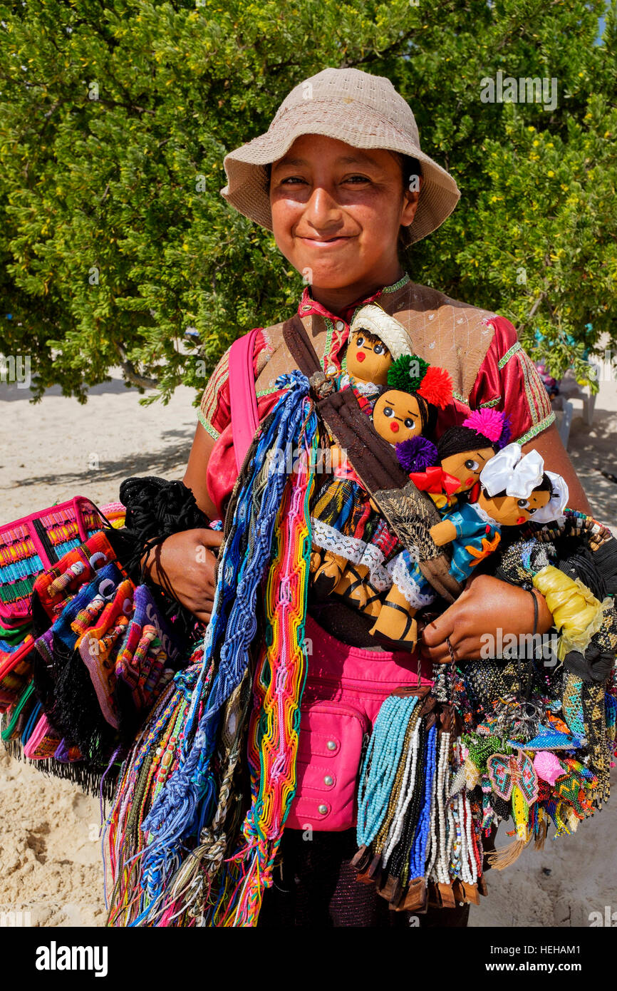 Young woman selling dolls, scarves and bracelets made from cotton and wool,  on the beach at Playa del Carmen, Cancun, Mexico Stock Photo - Alamy
