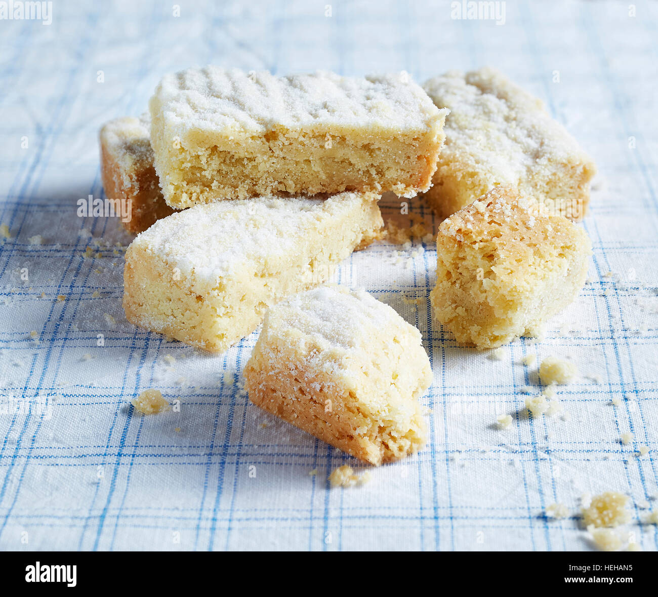 Shortbread, crumbly, crumbs, blue check table cloth, butter, biscuit, Scottish, traditional, food, sweet, stacked dusted icing sugar texture tea t Stock Photo