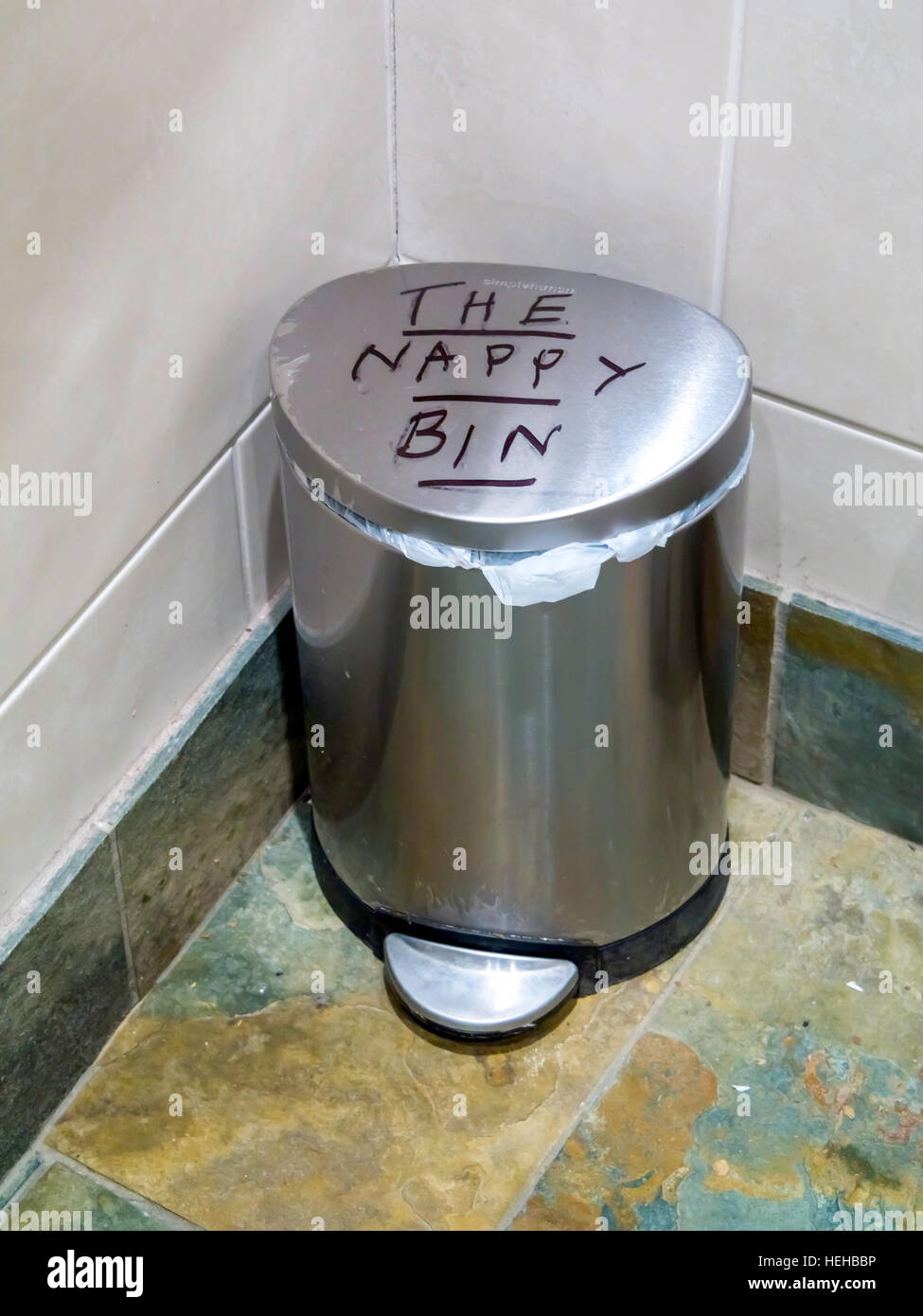 A stainless steel foot pedal operated waste bin with 'The Nappy Bin' written on top hygienic disposal of nappies Stock Photo