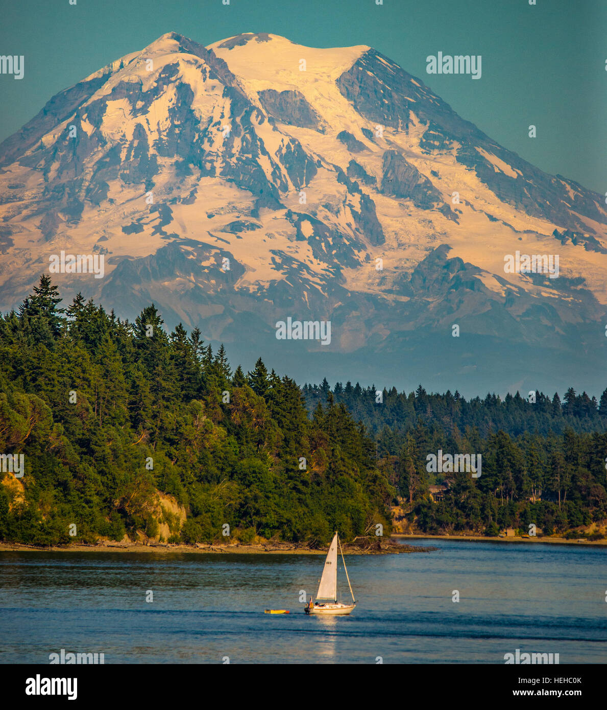 Sailboat sailing on the Puget Sound with snow covered  Mount Rainier in the background. Washington, USA Stock Photo
