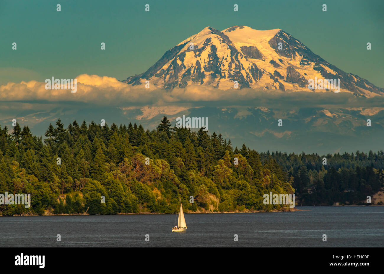 Close up of Mount Rainier and people sailing in sailboat. Puget Sound, Squaxin Island,  Washington, USA Stock Photo