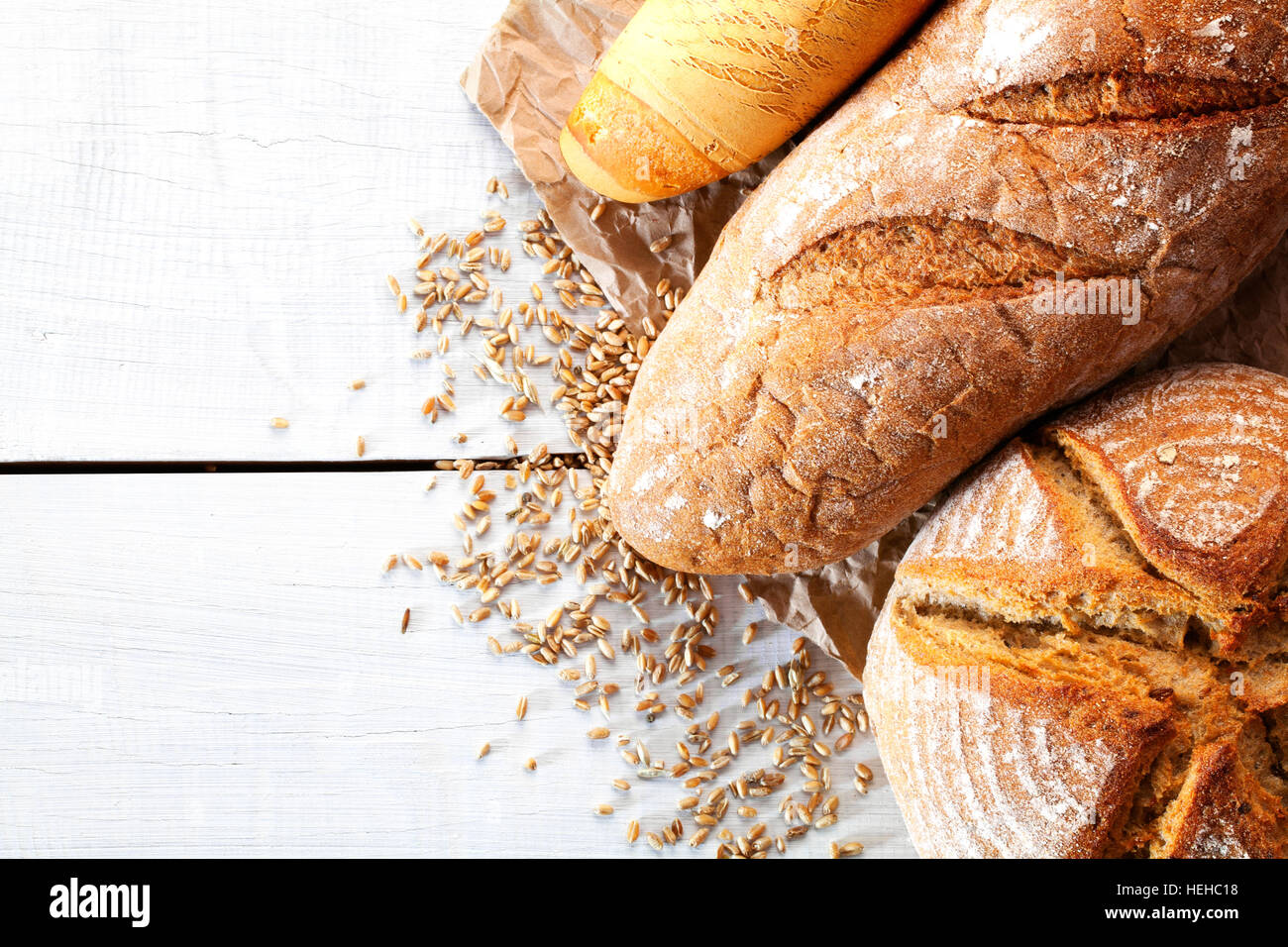 Assortment of baked bread on wooden table background Stock Photo - Alamy