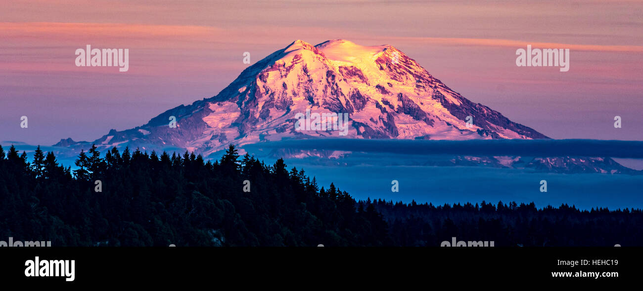 Colorful pink sunset lighting up snow covered Mount. Rainier, State of Washington, USA Stock Photo