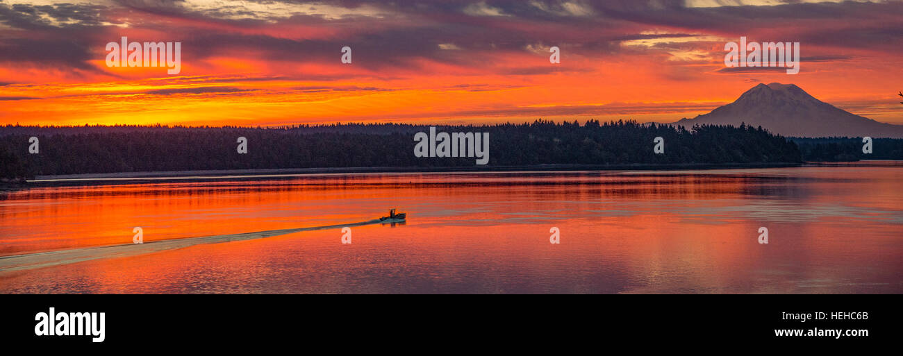 Fishing boat at sunrise crossing the Puget Sound with Mt. Rainier in background. Washington, USA Stock Photo