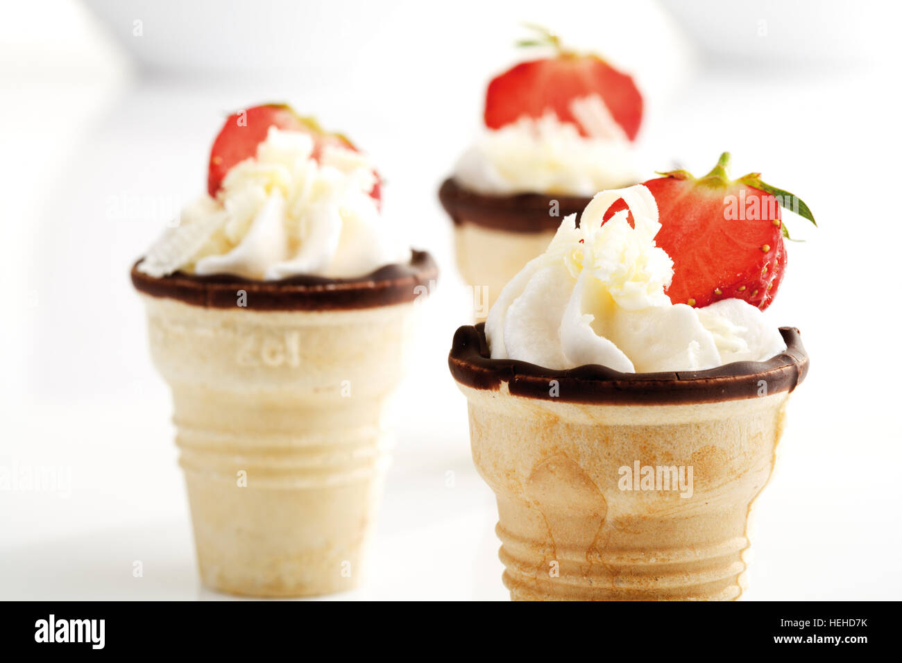 Whipped cream topped with strawberries served in waffle cones Stock ...