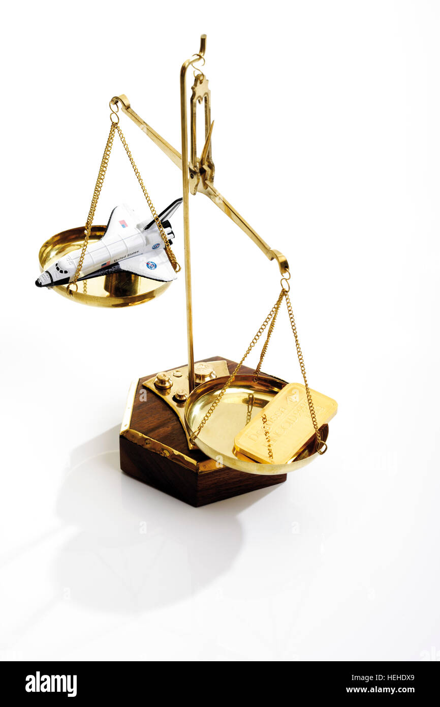 Scales with gold bars and a spaceship Stock Photo