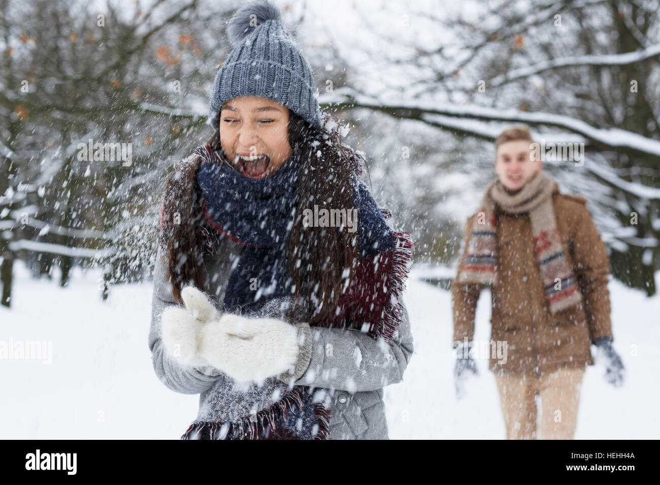 Dating couple playing snowballs on wintery day Stock Photo - Alamy
