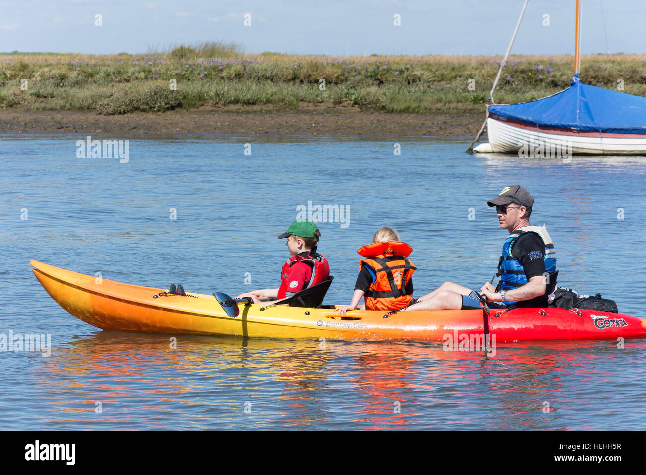 Father and children on kayak on River Burn, The Quay, Burnham Overy Staithe, Norfolk, England, United Kingdom Stock Photo