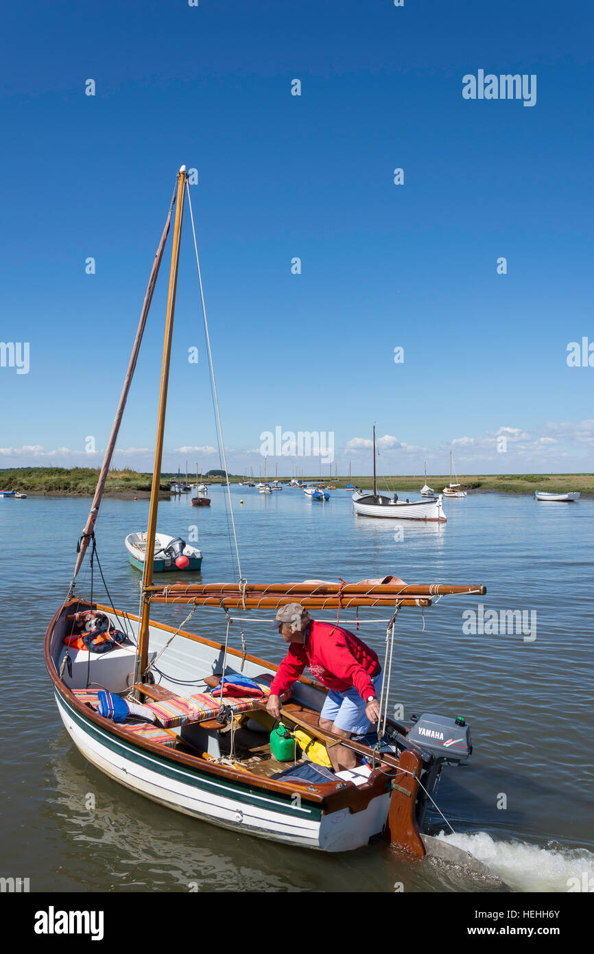 Man sailing traditional boat on River Burn, The Quay, Burnham Overy Staithe, Norfolk, England, United Kingdom Stock Photo