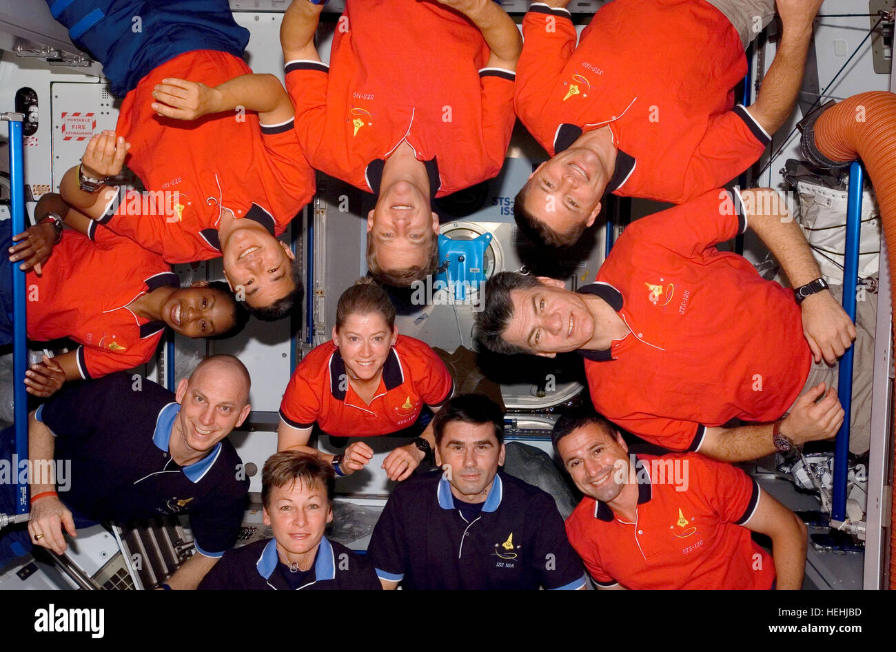 NASA STS-120 and Expedition 16 crew members astronauts (L-R) Peggy Whitson, Clayton Anderson, Stephanie Wilson, Daniel Tani, Scott Parazynski, Doug Wheelock, Italian astronaut Paolo Nespoli of the European Space Agency, George Zamka, Russian cosmonaut Yuri Malenchenko of Roscosmos, and Pam Melroy (center) put their heads in the center for a photo after a news conference in the International Space Station Harmony node while the space shuttle Discovery is docked with the station July 8, 2009 in Earth orbit. Stock Photo