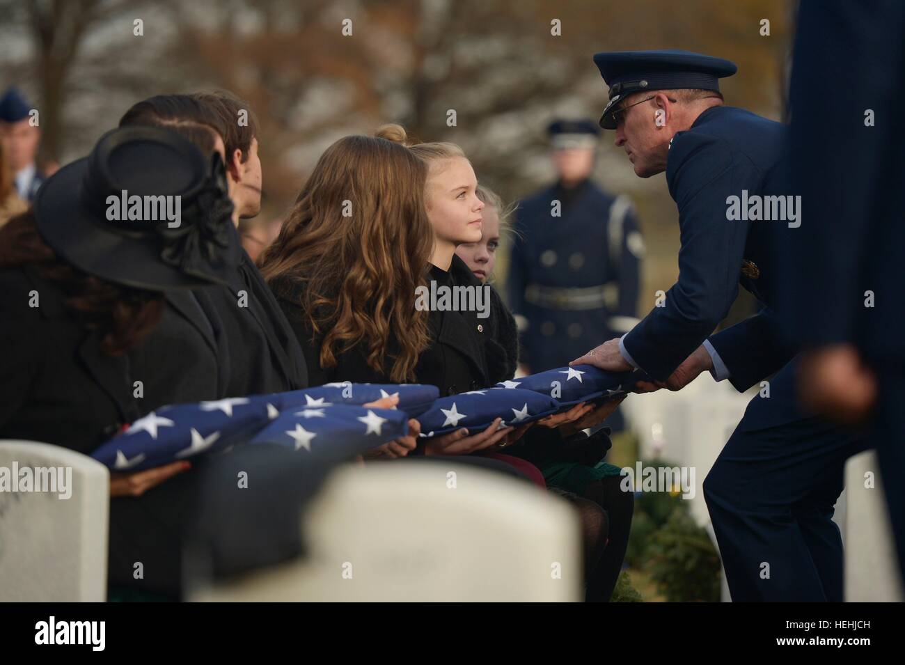 U.S. Air Force Assistant Deputy Chief of Staff of Operations Scott Vander Hamm presents a folded American flag to Annalise Gilbert during the interment for her father, fallen U.S. soldier Troy Gilbert at the Arlington National Cemetery December 19, 2016 in Arlington, Virginia. Gilbert was killed in 2006 when his F-16C Fighting Falcon aircraft crashed near Baghdad, Iraq during a combat mission. Stock Photo