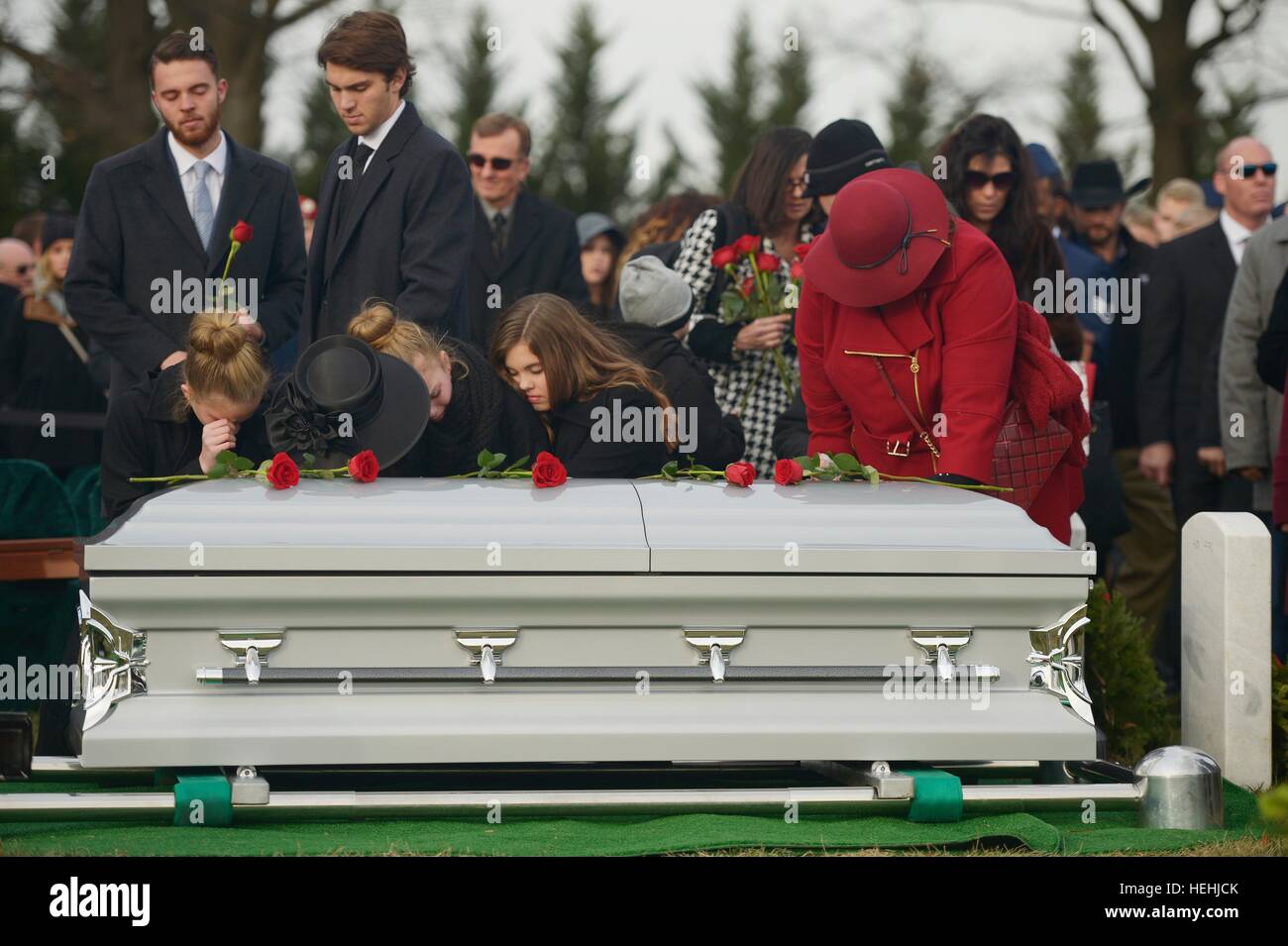 The family of U.S. Air Force soldier Troy Gilbert place roses on his casket during his interment service at the Arlington National Cemetery December 19, 2016 in Arlington, Virginia. Gilbert was killed in 2006 when his F-16C Fighting Falcon aircraft crashed near Baghdad, Iraq during a combat mission. Stock Photo
